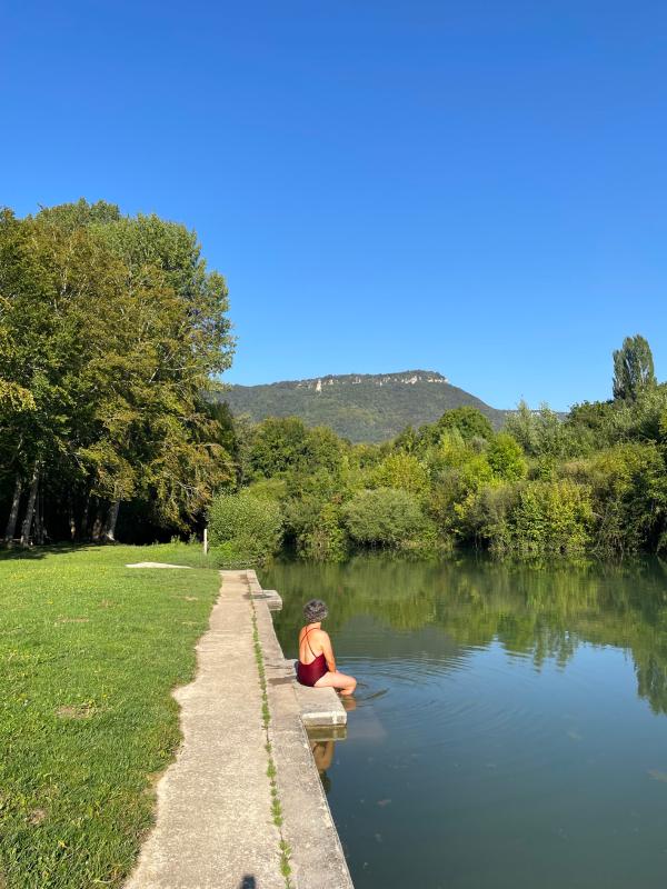 mujer metiendo los pies en una piscina fluvial